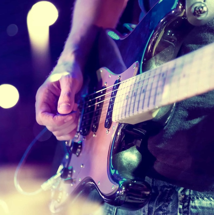 Close up of person playing electric guitar