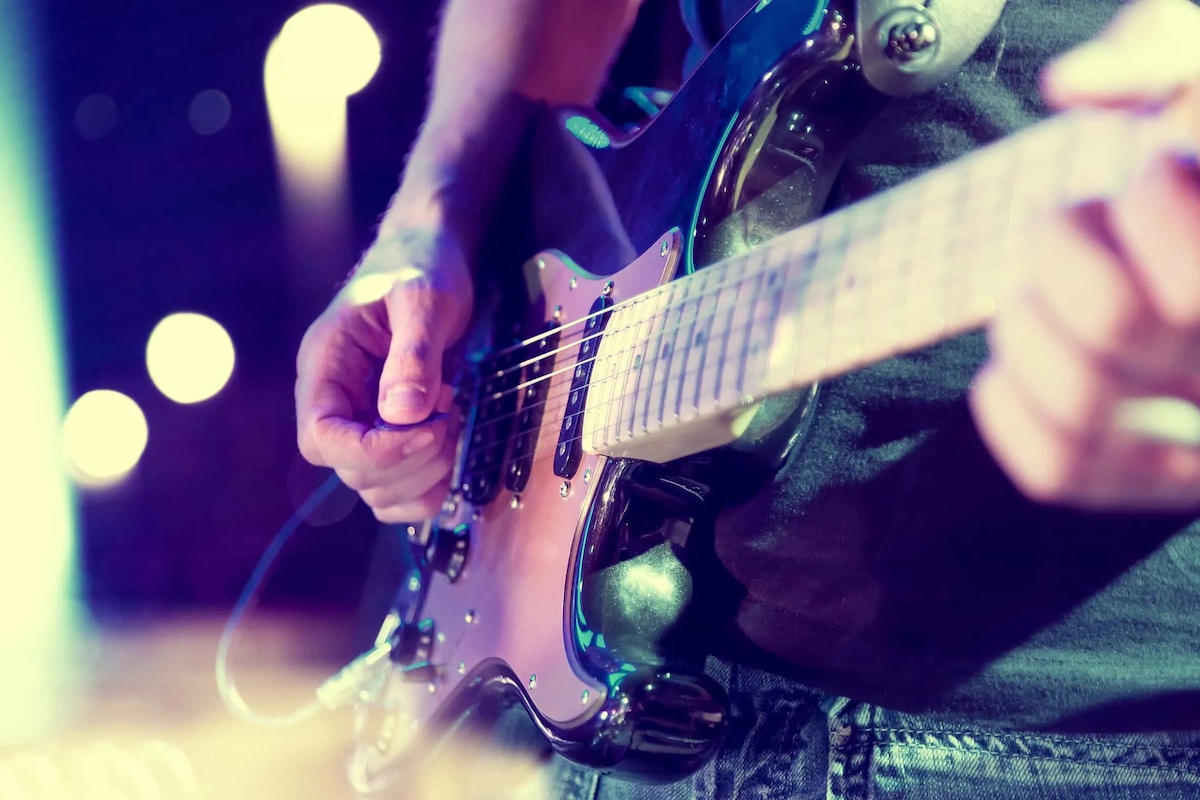 Close up of person playing electric guitar