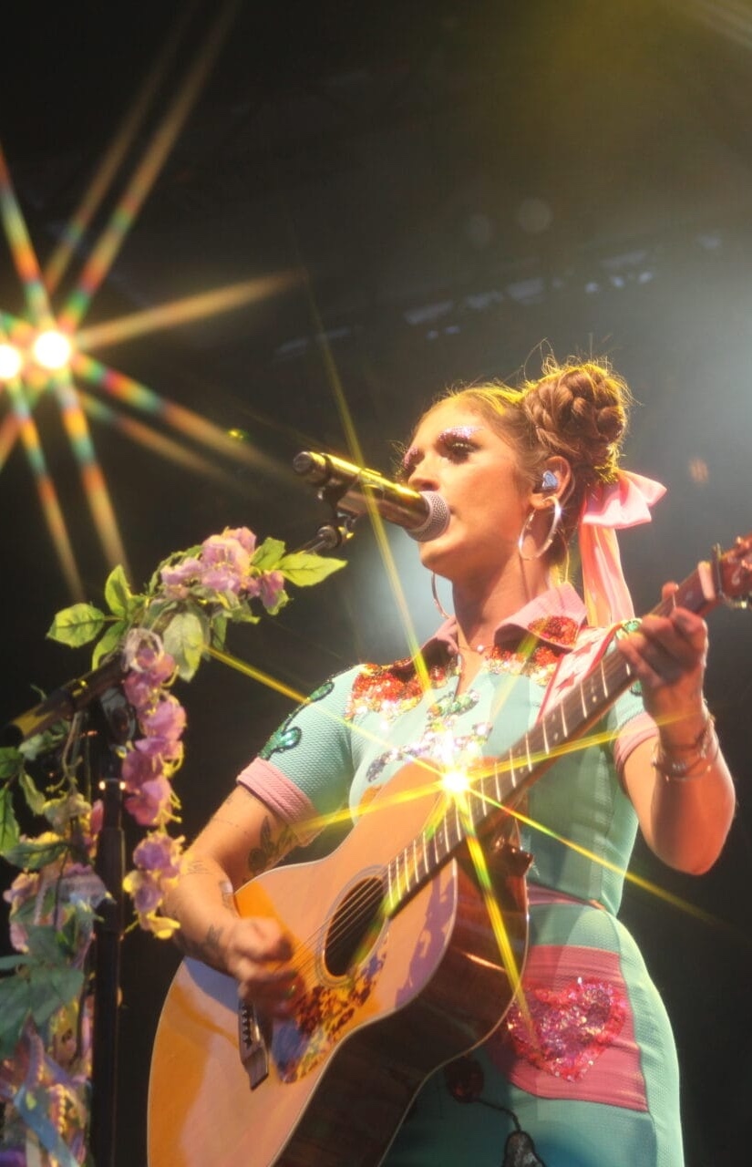 Woman playing guitar on stage